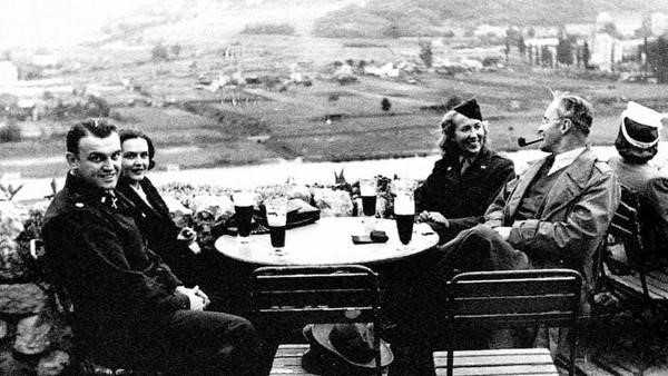 Maria Gulovich, right, with Allen Dulles smoking a pipe, in Prague. 1945.